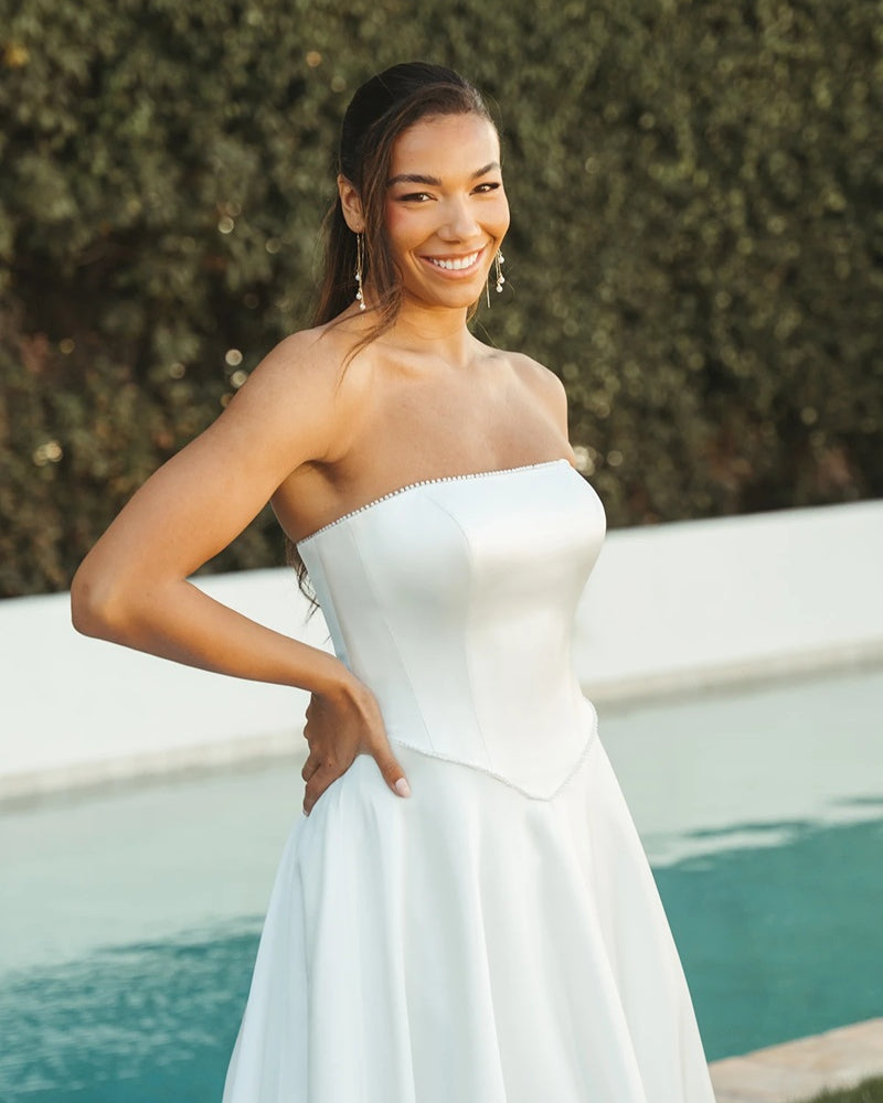 Bride wearing a strapless ivory wedding dress with boned corset.