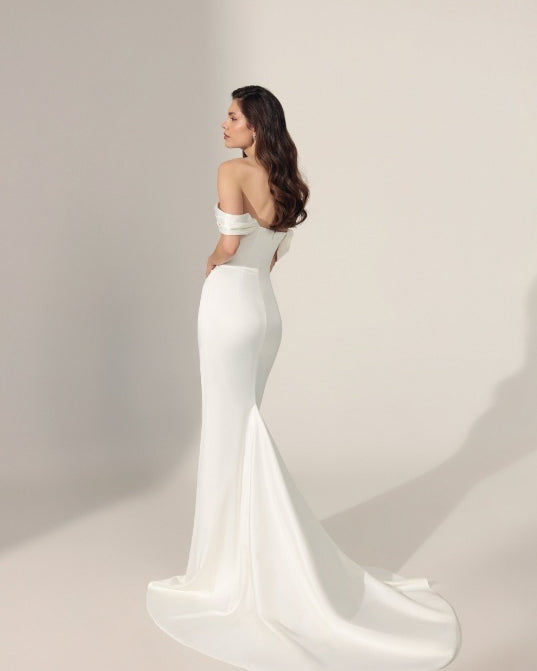 Off-the-shoulder ivory mermaid-style wedding gown with a long train.