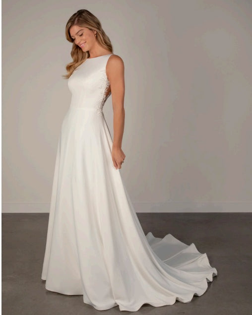 Bride wearing an ivory satin and lace boat neck a-line wedding dress.