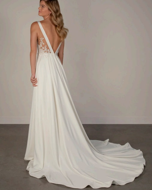 White ivory satin wedding dress with a long train, lace low back and a-line shape.