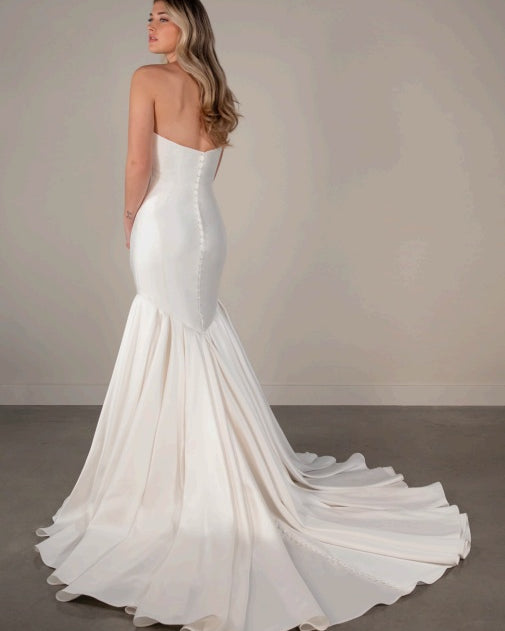 A ivory white strapless mermaid wedding dress with a long train.