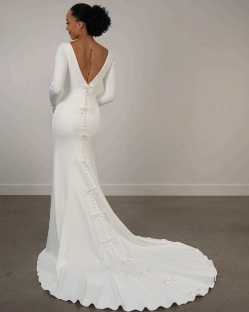 White ivory wedding dress with long sleeves, low back and a train.