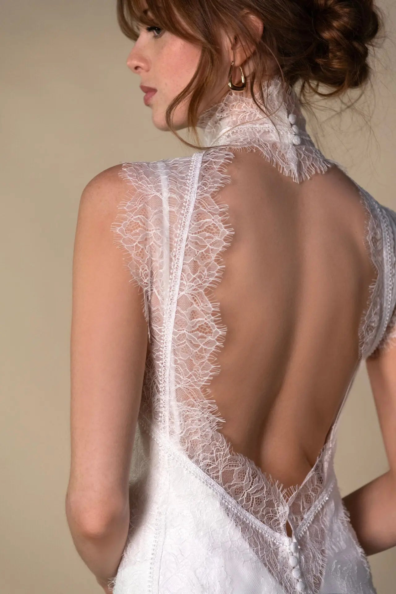 Lace and Charmeuse Sheath Wedding Dress with High Neckline and Keyhole Back. Delicate and effortless, the veda gown brings vintage romance to life with a relaxed, modern spirit. A layered two-piece look pairs an airy sandwashed charmeuse slip with a sheer lace overslip, creating soft texture and fluid movement in every step. The high neckline and slender straps lead to a striking keyhole back, while vintage-inspired lace trims and finishes give the gown unique charm.