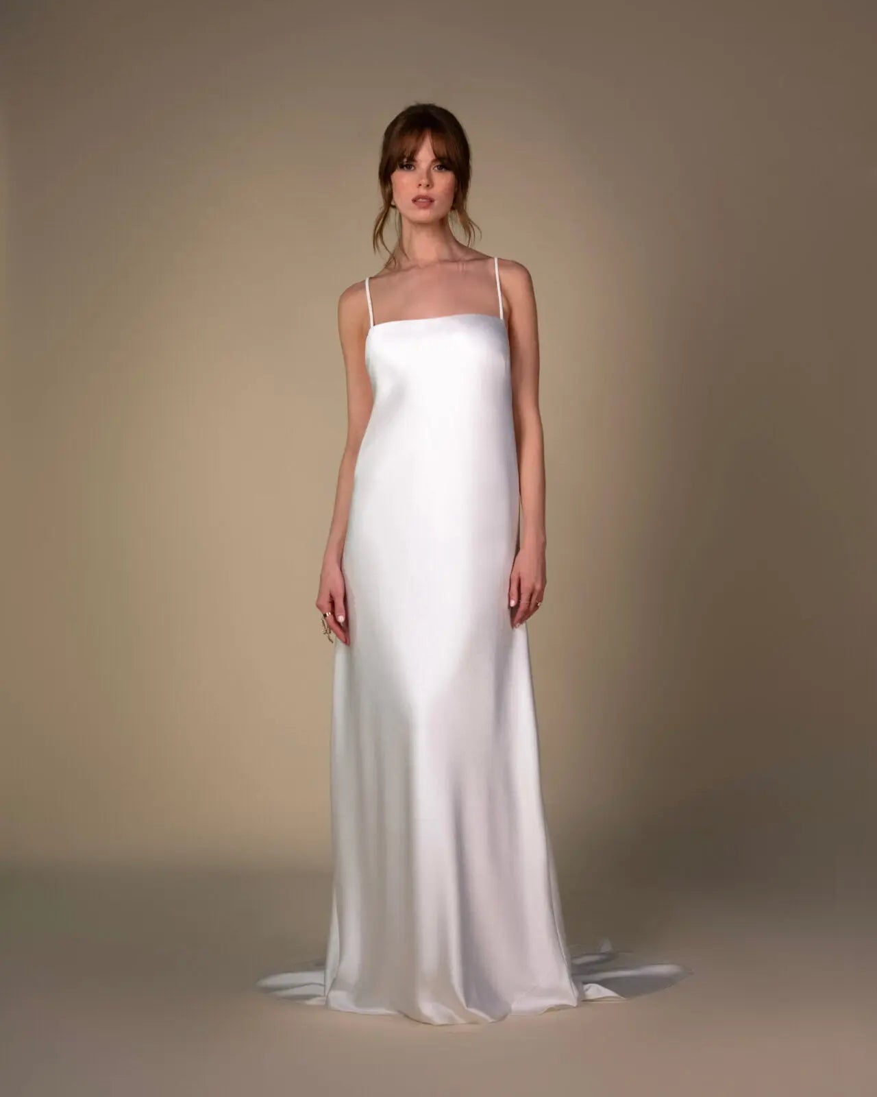Lace and Charmeuse Sheath Wedding Dress with High Neckline and Keyhole Back. Delicate and effortless, the veda gown brings vintage romance to life with a relaxed, modern spirit. A layered two-piece look pairs an airy sandwashed charmeuse slip with a sheer lace overslip, creating soft texture and fluid movement in every step. The high neckline and slender straps lead to a striking keyhole back, while vintage-inspired lace trims and finishes give the gown unique charm.