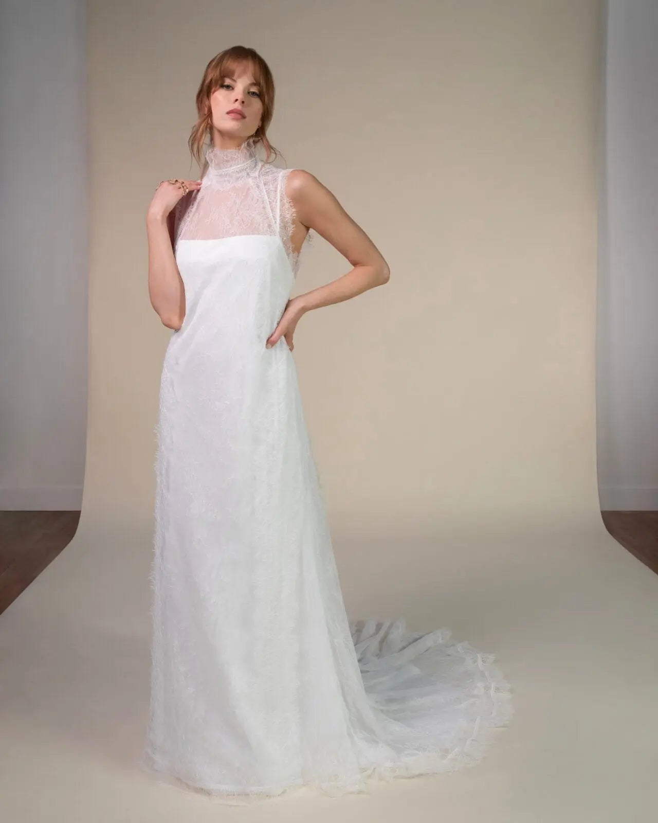 Lace and Charmeuse Sheath Wedding Dress with High Neckline and Keyhole Back. Delicate and effortless, the veda gown brings vintage romance to life with a relaxed, modern spirit. A layered two-piece look pairs an airy sandwashed charmeuse slip with a sheer lace overslip, creating soft texture and fluid movement in every step. The high neckline and slender straps lead to a striking keyhole back, while vintage-inspired lace trims and finishes give the gown unique charm.