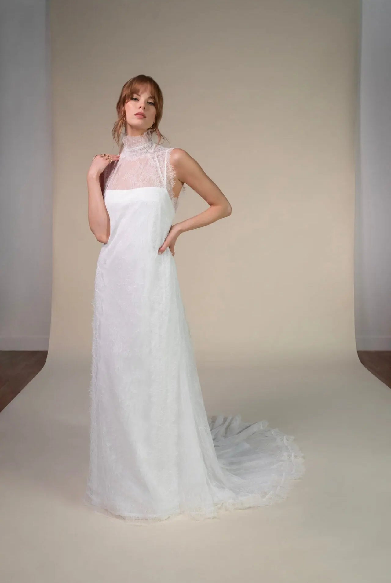 Lace and Charmeuse Sheath Wedding Dress with High Neckline and Keyhole Back. Delicate and effortless, the veda gown brings vintage romance to life with a relaxed, modern spirit. A layered two-piece look pairs an airy sandwashed charmeuse slip with a sheer lace overslip, creating soft texture and fluid movement in every step. The high neckline and slender straps lead to a striking keyhole back, while vintage-inspired lace trims and finishes give the gown unique charm.