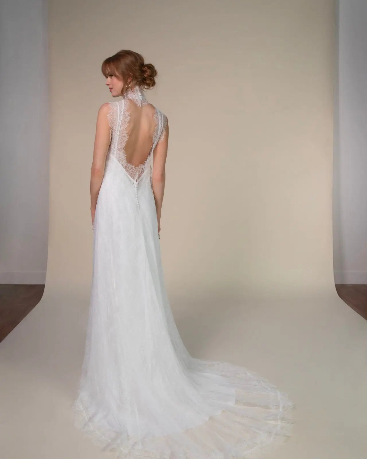 Lace and Charmeuse Sheath Wedding Dress with High Neckline and Keyhole Back. Delicate and effortless, the veda gown brings vintage romance to life with a relaxed, modern spirit. A layered two-piece look pairs an airy sandwashed charmeuse slip with a sheer lace overslip, creating soft texture and fluid movement in every step. The high neckline and slender straps lead to a striking keyhole back, while vintage-inspired lace trims and finishes give the gown unique charm.