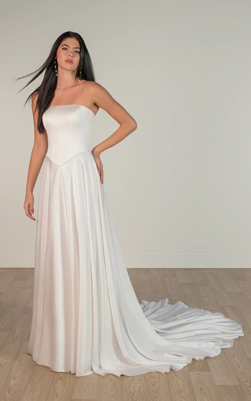 Bride wearing a strapless white ivory satin wedding dress with a flowing train, strapless neckline and boned corset.