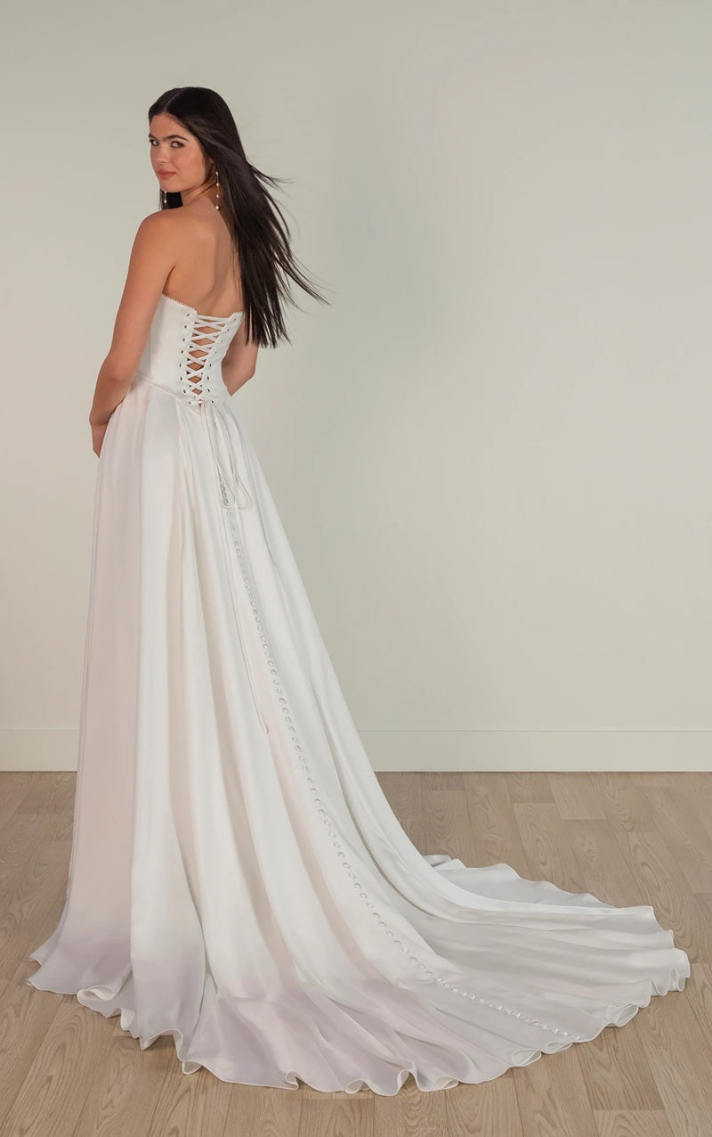 Woman wearing a white wedding dress with a flowing skirt on a plain background