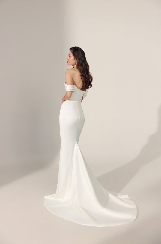 Off-the-shoulder ivory mermaid-style wedding gown with a long train.
