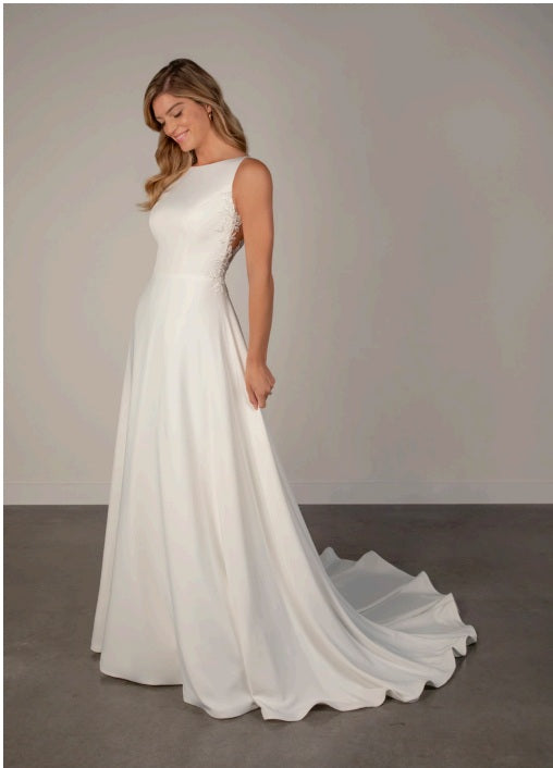Bride wearing an ivory satin and lace boat neck a-line wedding dress.