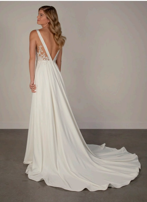 White ivory satin wedding dress with a long train, lace low back and a-line shape.