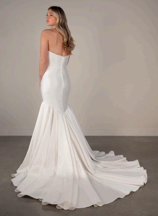 A ivory white strapless mermaid wedding dress with a long train.