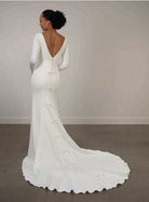 White ivory wedding dress with long sleeves, low back and a train.