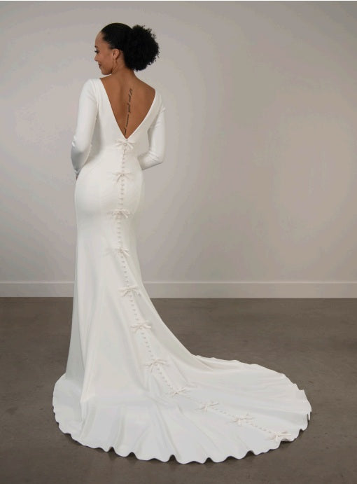 White ivory wedding dress with long sleeves, low back and a train.