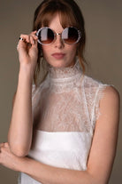Lace and Charmeuse Sheath Wedding Dress with High Neckline and Keyhole Back. Delicate and effortless, the veda gown brings vintage romance to life with a relaxed, modern spirit. A layered two-piece look pairs an airy sandwashed charmeuse slip with a sheer lace overslip, creating soft texture and fluid movement in every step. The high neckline and slender straps lead to a striking keyhole back, while vintage-inspired lace trims and finishes give the gown unique charm.