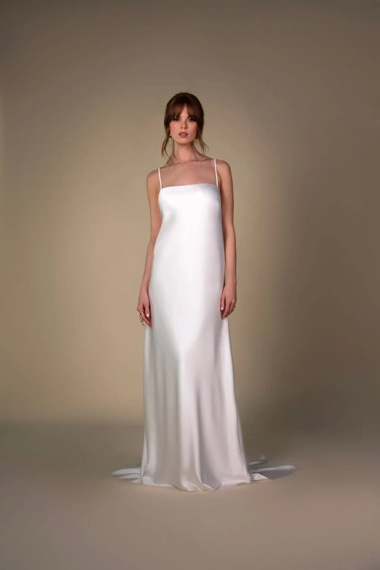 Lace and Charmeuse Sheath Wedding Dress with High Neckline and Keyhole Back. Delicate and effortless, the veda gown brings vintage romance to life with a relaxed, modern spirit. A layered two-piece look pairs an airy sandwashed charmeuse slip with a sheer lace overslip, creating soft texture and fluid movement in every step. The high neckline and slender straps lead to a striking keyhole back, while vintage-inspired lace trims and finishes give the gown unique charm.