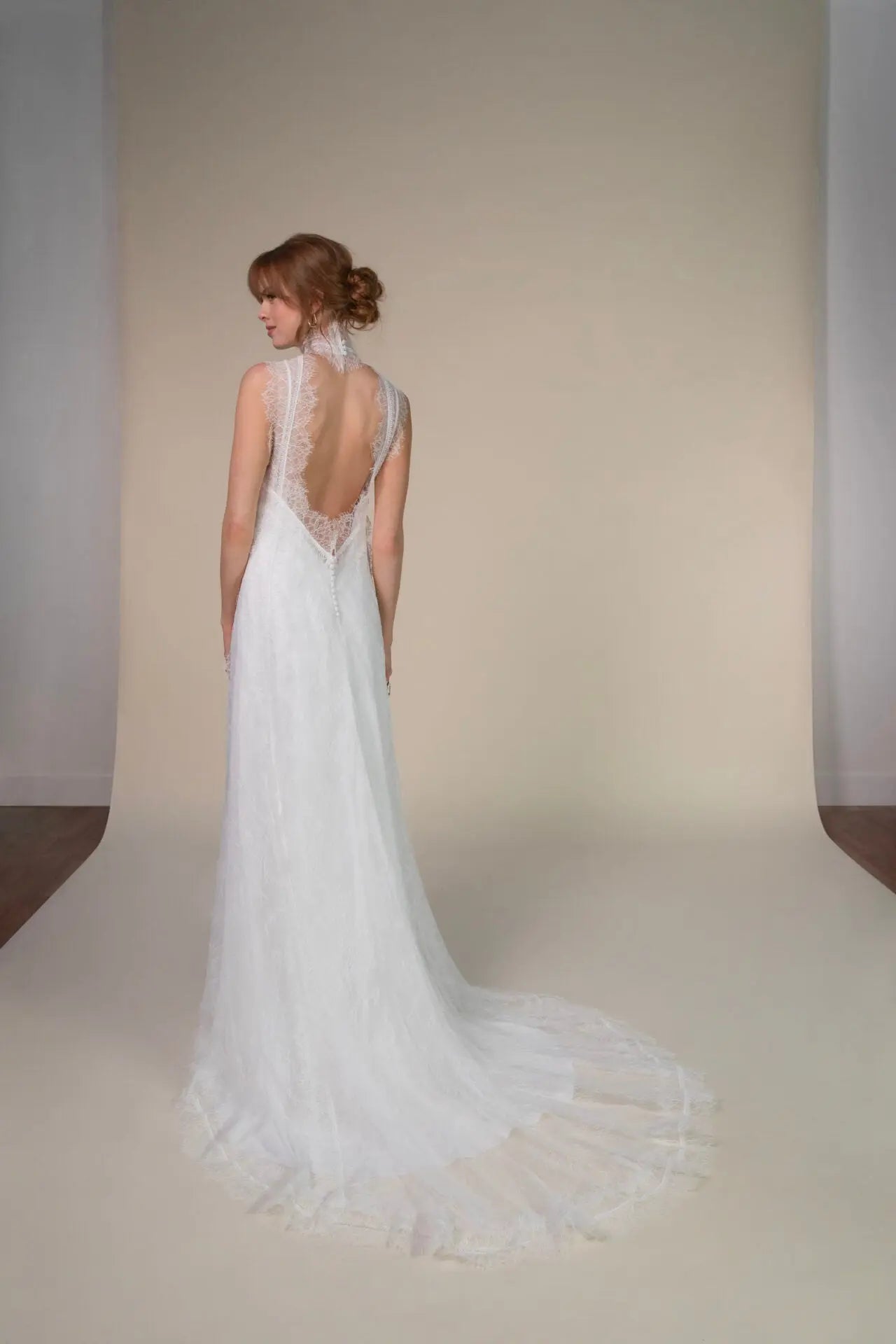 Lace and Charmeuse Sheath Wedding Dress with High Neckline and Keyhole Back. Delicate and effortless, the veda gown brings vintage romance to life with a relaxed, modern spirit. A layered two-piece look pairs an airy sandwashed charmeuse slip with a sheer lace overslip, creating soft texture and fluid movement in every step. The high neckline and slender straps lead to a striking keyhole back, while vintage-inspired lace trims and finishes give the gown unique charm.