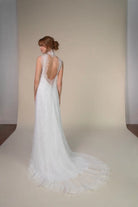 Lace and Charmeuse Sheath Wedding Dress with High Neckline and Keyhole Back. Delicate and effortless, the veda gown brings vintage romance to life with a relaxed, modern spirit. A layered two-piece look pairs an airy sandwashed charmeuse slip with a sheer lace overslip, creating soft texture and fluid movement in every step. The high neckline and slender straps lead to a striking keyhole back, while vintage-inspired lace trims and finishes give the gown unique charm.